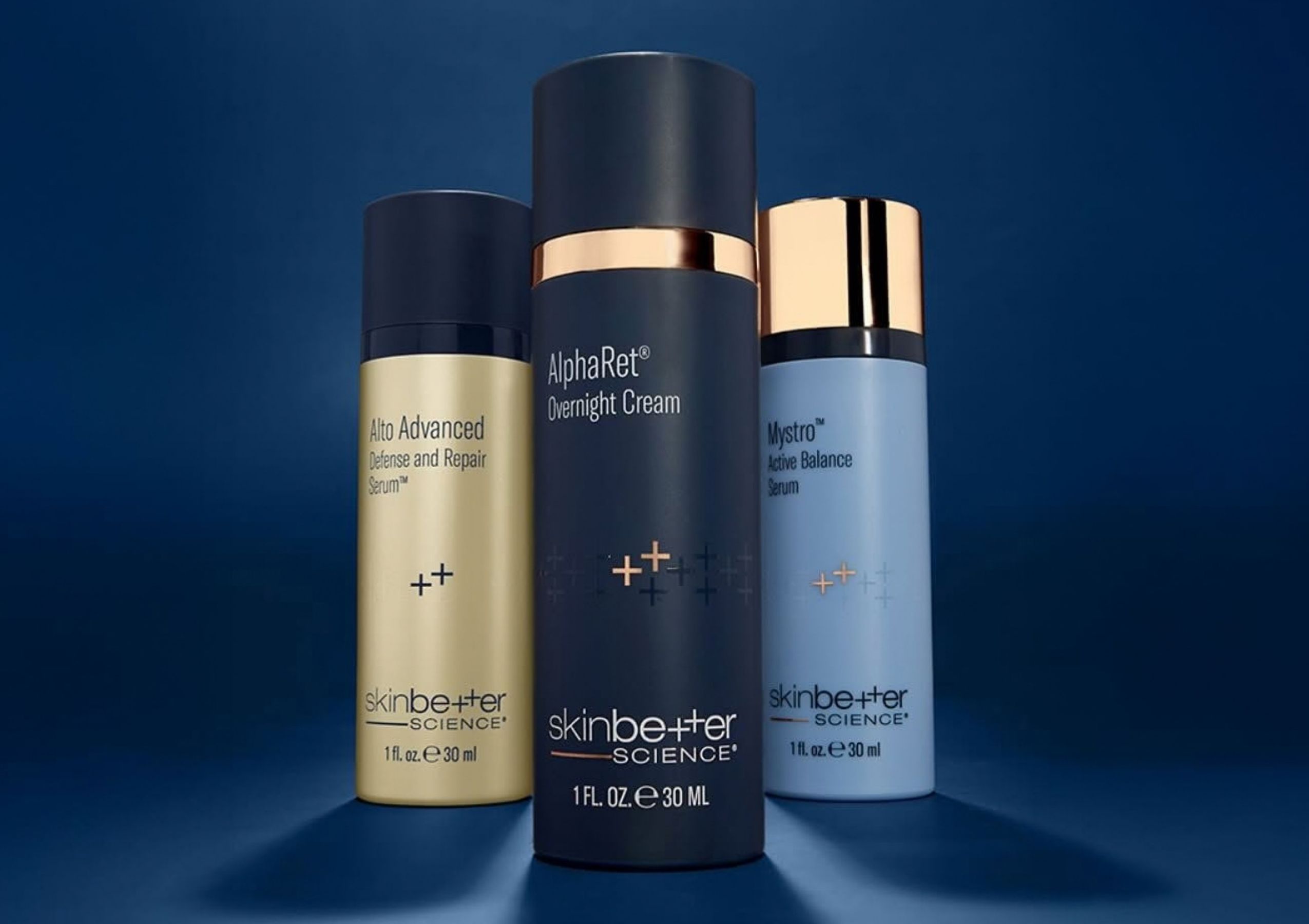 Three SkinCeuticals dropper bottles in a row: orange, clear, and purple liquids with black droppers against a gray background.